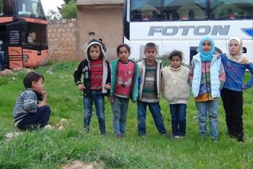 اطفال من بلدتي كفريا والفوعة يتجمعون امام الباصات استعدادا للرحيل