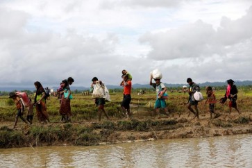 A group of Rohingya refugee people walk towards Bangladesh after crossing the Bangladesh-Myanmar border in Teknaf, Bangladesh. REUTERS/Mohammad Ponir Hossain