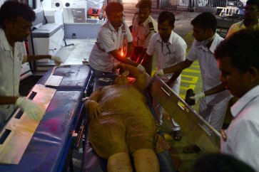 Sri Lankan hospital workers bring in a wounded woman to the main hospital in Colombo on April 14, 2017.
Emergency workers dug through tonnes of garbage in Sri Lanka's capital on April 14, 2017 after a massive rubbish dump buried an estimated 40 homes during the country's traditional new year. President Maithripala Sirisena ordered hundreds of troops and police to join firefighters in the Colombo rescue operation after the 300-foot (91-metre) high dump caught fire and collapsed, officials said. / AFP PHOTO / LAKRUWAN WANNIARACHCHI