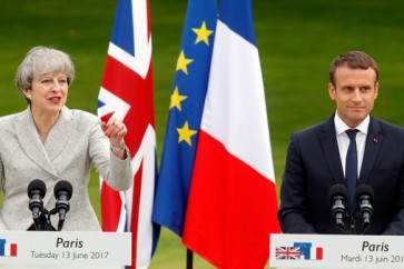 French President Emmanuel Macron (R) listens to Britain's Prime Minister Theresa May as they attend a joint press conference at the Elysee Palace in Paris, France, June 13, 2017.    REUTERS/Philippe Wojazer