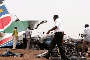 Aviation staff walk through the wreckage of a South Supreme Airlines plane that crashed when it landed in the northwestern town of Wau from South Sudan's capital Juba, March 21, 2017. REUTERS/Jok Solomun FOR EDITORIAL USE ONLY. NO RESALES. NO ARCHIVE.