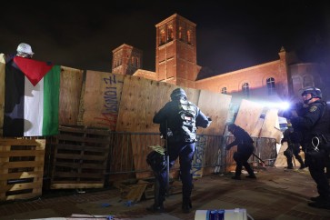 LOS ANGELES, CALIFORNIA - MAY 02: California Highway Patrol (CHP) officers work to clear a pro-Palestinian encampment as a protestor holds a Palestinian flag after dispersal orders were given at the University of California, Los Angeles (UCLA) campus, on May 2, 2024 in Los Angeles, California. The camp was declared unlawful by the university and scores of protestors who refused to leave were detained during the operation. Pro-Palestinian encampments have sprung up at college campuses around the country with some protestors calling for schools to divest from Israeli interests amid the ongoing war in Gaza.   Mario Tama/Getty Images/AFP (Photo by MARIO TAMA / GETTY IMAGES NORTH AMERICA / Getty Images via AFP)