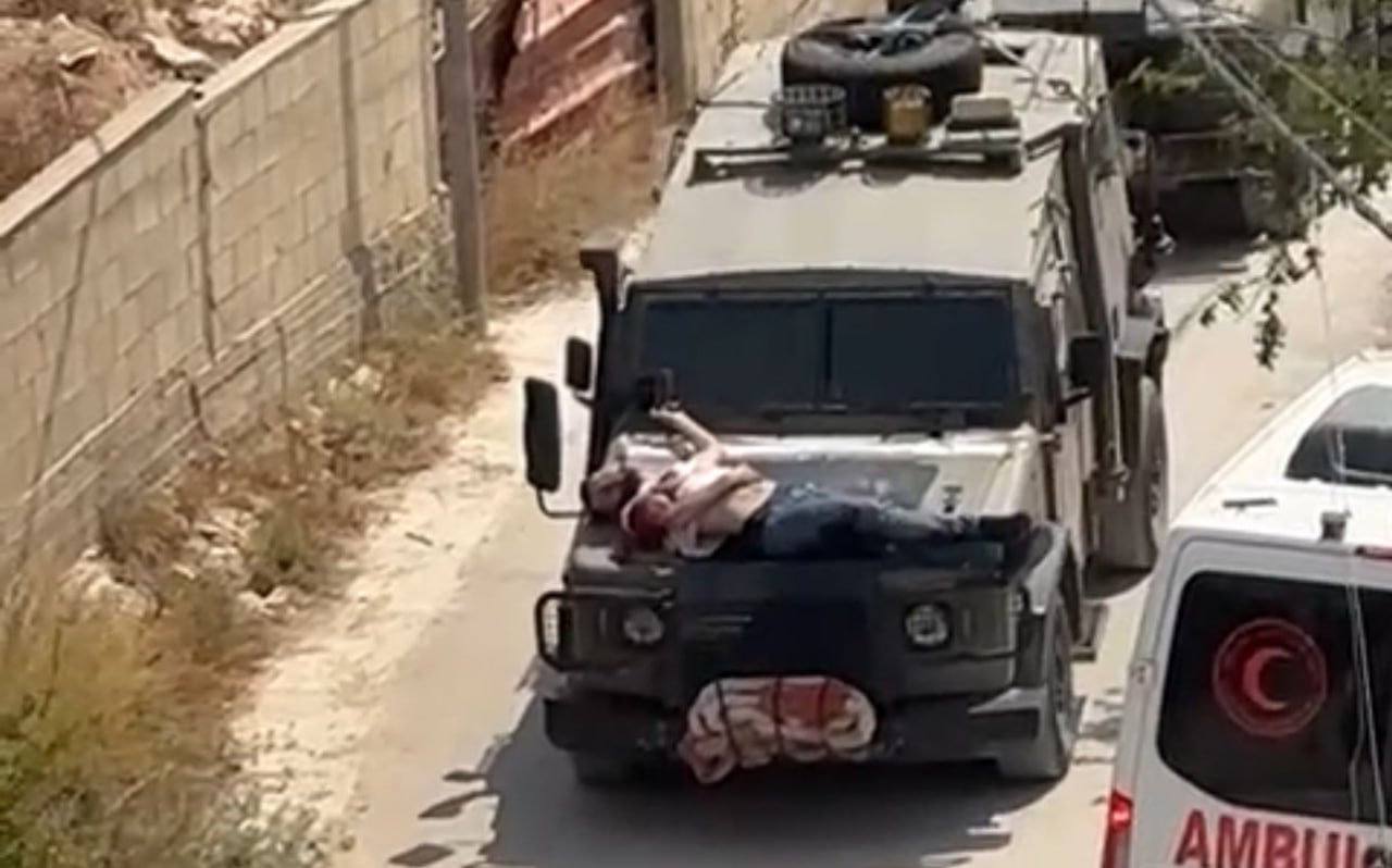 صورة للتنكيل بالشاب المصاب في حي الجابريات بجنين ووضعه على آلية عسكرية