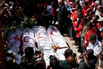 فلسطينيون يشيعون 14 شهيدا من الدفاع المدني والهلال الأحمر بخانيونس (رويترز)